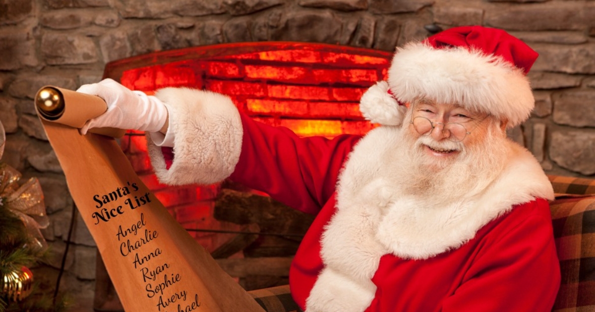 Santa reading his naughty-and-nice list beside a decorated mantel